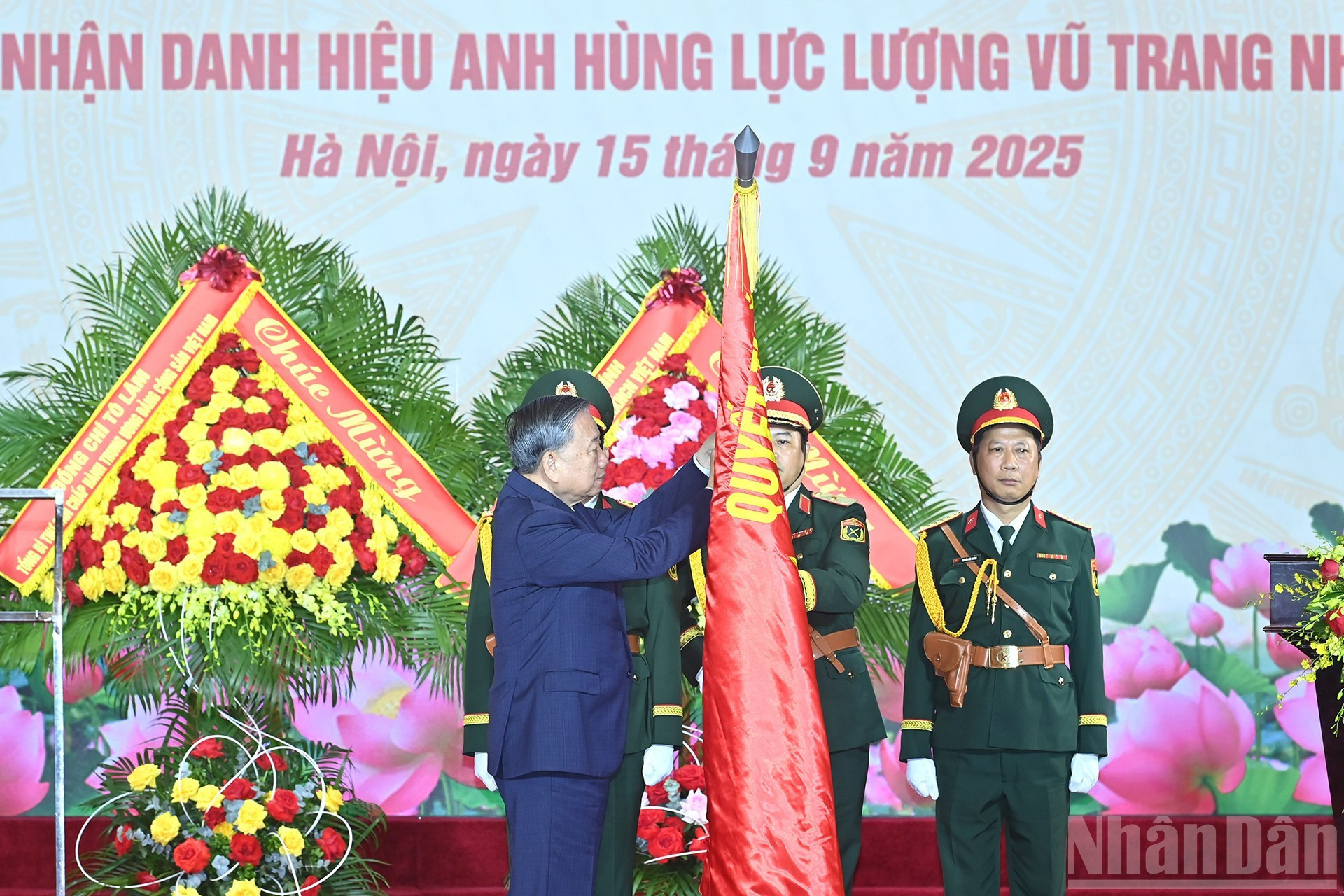 To Lam coloca el Título de Héroe de Fuerzas Armadas Populares en la bandera tradicional del Departamento General de la Industria de Defensa.