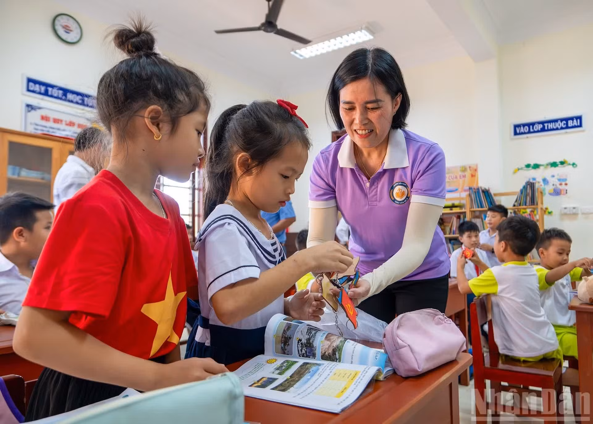 La profesora Ngo Thi Lan entrega los pequeños regalos hechos a mano por los estudiantes de la escuela primaria Chu Van An A a los niños de la isla Da Tay.