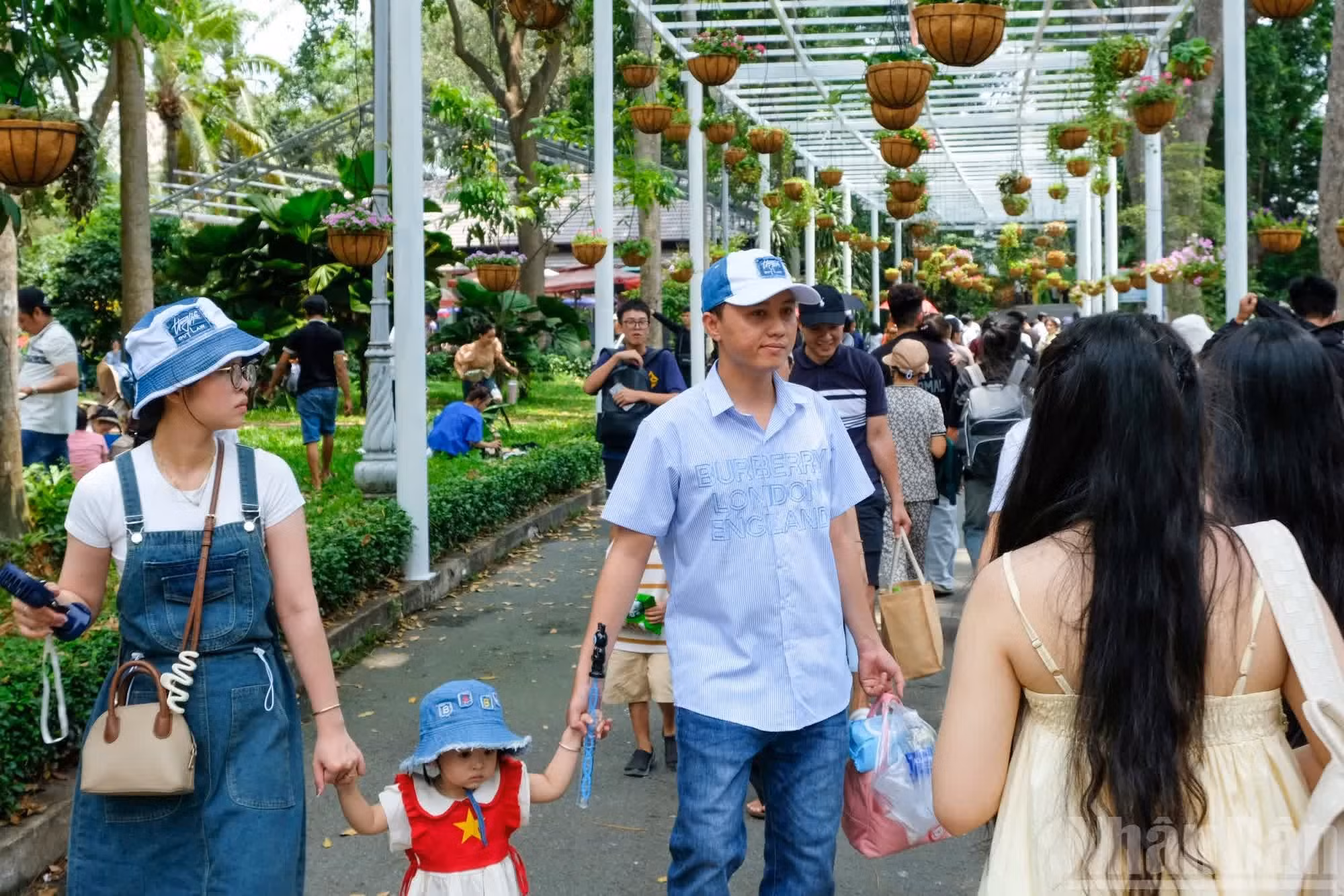 En el Jardín Zoológico y Botánico de Saigón, los tonos rojo y amarillo de las camisetas con la bandera de Vietnam de visitantes locales y extranjeros llenan el espacio, transmitiendo orgullo y conexión con la cultura vietnamita.