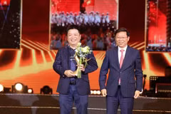 Tran Thanh Lam (derecha), miembro del Comité Central del Partido Comunista de Vietnam y subjefe de su Comisión de Propaganda y Movilización de Masas, entrega al redactor subjefe de Nhan Dan Que Dinh Nguyen la estatuilla honorífica dirigida al programa “La Patria en el corazón”. (Foto: Nhan Dan)