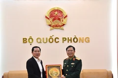 El jefe del Estado Mayor General del Ejército Popular de Vietnam y viceministro de Defensa, general Nguyen Tan Cuong (derecha), entrega un obsequio al coronel general Saichay Kommasith, viceministro de Defensa y jefe del Estado Mayor General del Ejército Popular de Laos. (Foto: qdnd.vn)