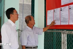 Electores consultan las reseñas biográficas de los candidatos al Consejo Popular de la comuna de Tan Hong (Dong Thap) para el período 2026-2031. (Foto: VNA)