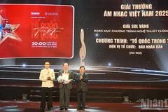 Un representante del diario Nhan Dan recibe el Sol de Oro en la categoría de Programa político-artístico 2025 por el concierto “Patria en el corazón”. (Foto: Linh Bao)