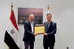 El embajador de Vietnam en Egipto, Nguyen Nam Duong, entrega un regalo al profesor y doctor Ahmed Ghoneim, director del Gran Museo Egipcio. 