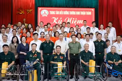 El secretario general del PCV y presidente del Estado, To Lam (centro, de pie, primera fila), posa para una foto grupal con el personal, los inválidos y los soldados enfermos en el Centro de Atención para Inválidos de Thuan Thanh. (Foto: VNA)