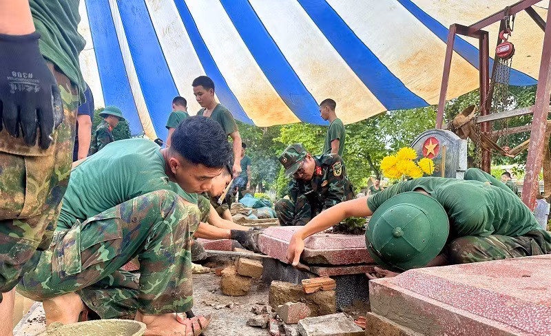 Los oficiales y soldados del Alto Mando Militar de la provincia de Dien Bien restituyen las tumbas a su estado original una vez finalizado el proceso de toma de muestras.