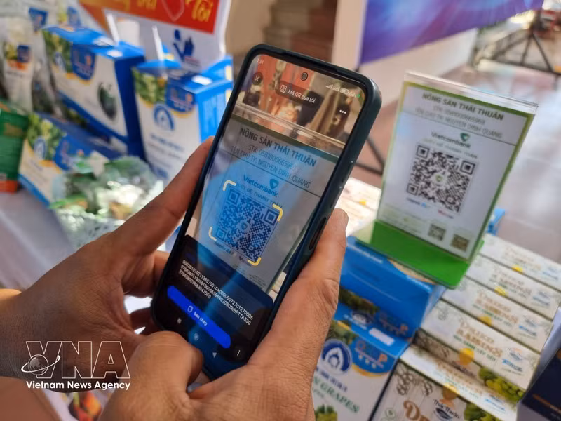 Un cliente realiza una transferencia instantánea mediante el escaneo de un código QR. (Foto: VNA)