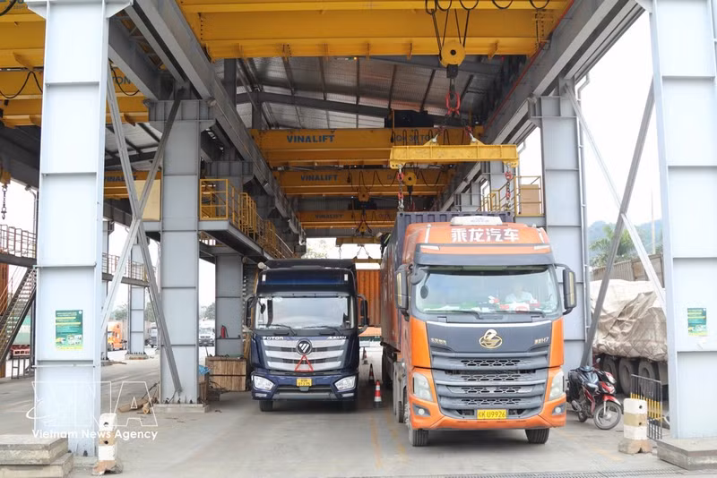Los contenedores se transbordan en la terminal de camiones de Xuan Cuong, en la zona del puesto fronterizo internacional de Huu Nghi. (Foto: VNA)