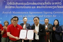 El director gerente de Lao Airlines Khamla Phommavanh (derecha) y el director ejecutivo de VietJet Air Dinh Viet Phuong muestran el acuerdo firmado. (Foto: VNA)