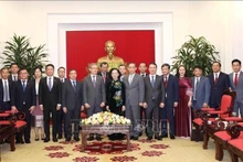 La representante permanente de la Secretaría de PCV Truong Thi Mai (Centro) y la delegación de la Comisión de Relaciones Exteriores de Laos. (Foto: VNA)
