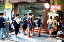 Turistas extranjeros hacen fila para comprar Banh Mi (bocadilllo vietnamita) en una tienda en la calle Ly Quoc Su, en Hanói.