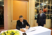 El primer ministro tailandés, Srettha Thavisin, escribe en el libro de condolencias. (Foto: VNA)