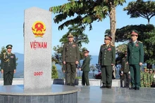 Los generales Phan Van Giang, Chansamone Chanyalath y Tea Seiha en el hito del cruce fronterizo entre Vietnam y Laos y Camboya. (Foto: VNA)