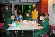 Los guardias fronterizos del puerto de Ba Ria-Vung Tau llevan a cabo los procedimientos de entrada para los ocho ciudadanos birmanos evacuados. (Fotografía: VNA)