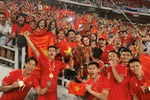 Jugadores de la selección nacional de fútbol celebran el triunfo con los fanáticos. (Foto: VNA)