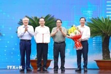 El primer ministro vietnamita, Pham Minh Chinh (segundo desde la derecha), entrega a las autoridades locales la decisión que aprueba la planificación de Ciudad Ho Chi Minh. (Foto: VNA)
