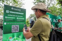 Un hombre escanea el código QR de la plataforma de comercio electrónico VinachemMart. (Foto: VNA)