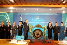 El viceministro de Finanzas, Nguyen Duc Chi, hace un toque del gong para abrir la bolsa de valores a principios de 2023. (Fotografía: nhandan.vn)