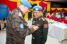 El subcomandante de la policía de la UNMISS, Murat Isik, presenta la medalla de mantenimiento de la paz de la ONU al primer coronel Le Quoc Huy. (Foto: VNA)