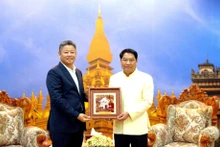 El vicepresidente del Comité Popular de Hanói, Nguyen Manh Quyen (Derecha), entrega un regalo al miembro del Comité Central del Partido Popular Revolucionario de Laos, subsecretario del Comité partidista y alcalde de Vientián, Atsaphanthong Siphandone. (Foto: hanoimoi.vn)