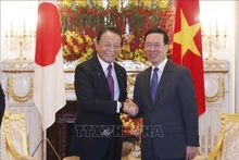 El presidente de Vietnam, Vo Van Thuong (derecha), recibe al vicepresidente del PLD, Aso Taro. (Foto: VNA)