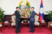 El embajador de Vietnam en Laos, Nguyen Ba Hung entrega flores para felicitar el 48º Día Nacional de la República Democrática Popular Lao. (Foto: VNA)