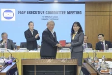 Chu Thi Lan Huong, presidenta de la Asociación Filatélica de Vietnam y directora general adjunta de la Corporación de Correos de Vietnam, entrega el símbolo del tambor de bronce a los participantes. (Foto: VNA)