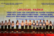 El comité organizador entrega obsequios a los estudiantes con excelentes logros académicos vietnamitas y chinas en Hai Phong. (Foto: VNA)