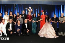 La embajadora adjunta de Vietnam en el Reino Unido, To Minh Thu (con un Ao Dai verde), se toma una foto con los ganadores. (Foto: VNA)