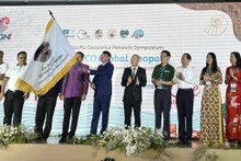El presidente del Comité Popular de Cao Bang, Hoang Xuan Anh, y la delegación del Geoparque Mundial de la Unesco de Non Nuoc Cao Bang reciben la bandera para albergar la próxima edición del evento. (Fotografía: thoidai.com.vn) 