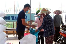 Entrega de arroz a los pobladores. (Foto: VNA)