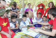 Una delegación de vietnamitas residentes en el extranjero entrega libros y regalos a los niños de Truong Sa. (Foto: VNA)