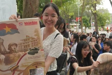 [Foto] Lectores felices de recibir publicación informativa especial de Nhan Dan 