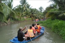 Los turistas experimentan el canotaje en el río en la granja de cabras turísticas Dong Nghi, provincia sureña de (Tien Giang. (Foto: VNA)