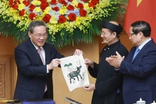 El primer ministro vietnamita, Pham Minh Chinh, y su par chino, Li Qiang, experimentan la elaboración de una pintura folclórica de Dong Ho.
