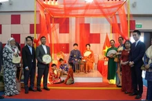 Los delegados toman fotos con modelos vietnamitas en el Ao dai.