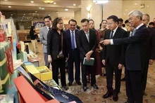 Los delegados visitan una exposición en el foro. (Foto: VNA)