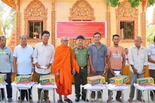 El primer coronel Le Thanh Hung entrega obsequios a los pobladores del distrito de Vinh Loi. (Foto: VNA) 