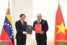 El secretario del Comité Central del PCV y jefe de su Comisión de Asuntos Internos Phan Dinh Trac, y el primer vicepresidente del PSUV, Diosdado Cabello, firman un acuerdo de cooperación entre el PCV y el PSUV. (Foto: VNA)