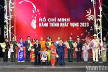 El presidente Vo Van Thuong y el jefe de la Comisión de Comunicación y Educación del CC del PCV, Nguyen Trong Nghia, entregan flores a los ejemplos destacados del programa. 