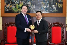 El residente-editor de Nhan Dan, Le Quoc Minh, entrega obsequio al embajador de Estados Unidos en Hanói, Marc E. Knapper.