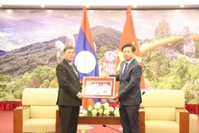 El vicepresidente de la Asamblea Nacional, Khambay Damlat, regala un cuadro al vicesecretario permanente del Comité partidista y presidente del Consejo Popular de Da Nang, Luong Nguyen Minh Triet. 