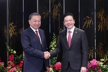 El secretario general del Partido Comunista de Vietnam, To Lam, (izquierda) y el primer ministro de Singapur, Lawrence Wong, copresiden una rueda de prensa para anunciar los resultados de sus conversaciones. (Foto: VNA)