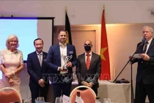 El embajador vietnamita en Bélgica, Nguyen Van Thao, entrega copa al ganador. (Foto: VNA)