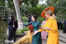 Nguyen Thi Minh Nguyet, esposa del presidente Luong Cuong, y la reina Matilde de Bélgica, alimentan a los peces en el estanque de Tío Ho, en el sitio de reliquias del Presidente Ho Chi Minh. (Foto: VNA)