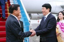 Luong Cuong, miembro del Buró Político y permanente del Secretariado del PCV, da la bienvenida al máximo dirigente laosiano, Thongloun Sisoulith, y a su esposa, en el aeropuerto internacional de Noi Bai. (Foto: VNA)