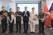 El embajador Dang Hoang Giang, jefe de la misión permanente de Vietnam ante la ONU, entre flores a oficiales connacionales participantes en las actividades del mantenimiento de la paz de las Naciones Unidas. (Foto: VNA)