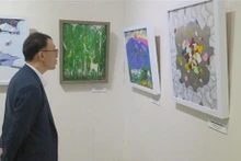 Un ciudadano surcoreano contempla obras exhibidas en el evento. (Fotografía: VNA)