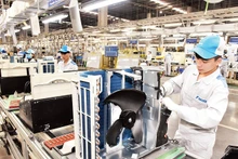 El gobierno implementa un sistema de soluciones para resolver las dificultades de las empresas. En la foto: Obreros de la Sociedad Anónima Daikin ensamblan acondicionadores de aire. (Fotografía: Dong Minh)