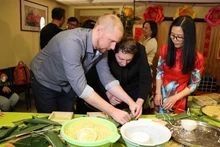 Los amigos belgas aprenden a hacer el banh chung. (Foto: VNA)